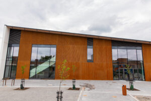 På bilden syns kulturhusets fasad. Den har orangebrun träpanel och stora fönsterelement.och