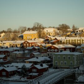 På helikopterbilden syns Borgå och gamla stan i Borgå. I förgrunden syns bron över Borgå å. Hustaken är täckta av snö och himlen är blekblå.